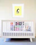 Yellow Emperor Penguin Dad and Baby Art Print in White Frame Hanging Over Baby Crib